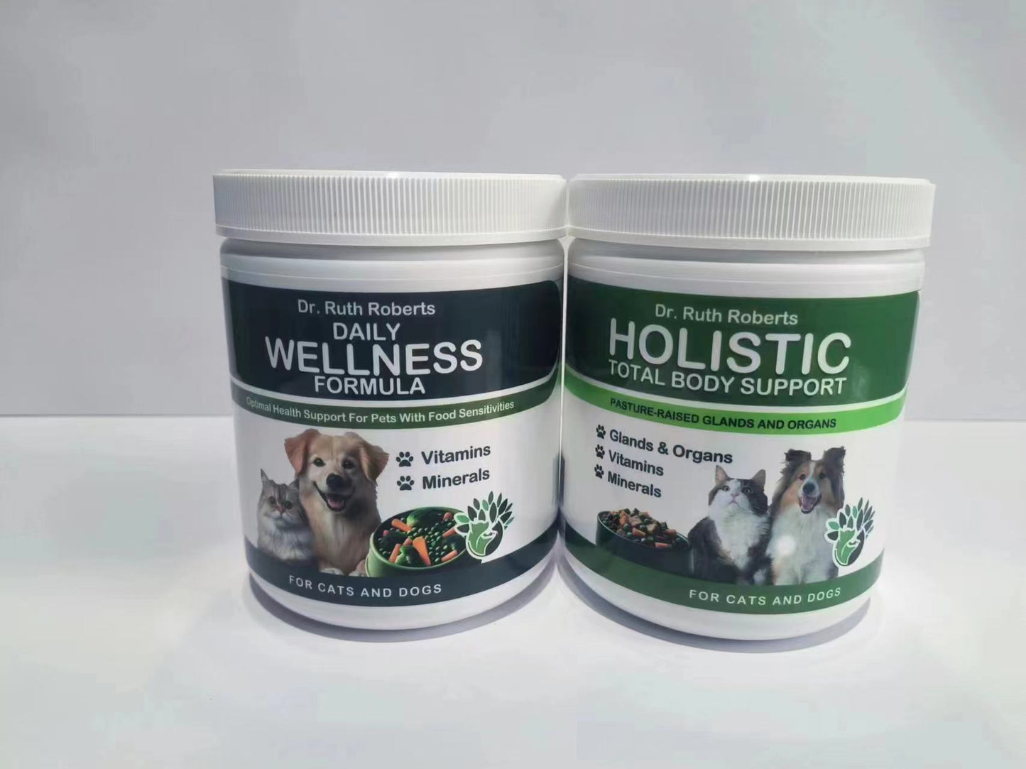 Two Dr. Ruth Roberts pet supplements: The left container, "Daily Wellness Formula," supports "Optimal Health For Pets With Food Sensitivities" and provides "Vitamins" and "Minerals." The right container, "Holistic Total Body Support," emphasizes "Pasture-Raised Glands and Organs" and supports "Glands & Organs," "Vitamins," and "Minerals." Both feature images of a dog, cat, and vegetables, and are "For Cats and Dogs."