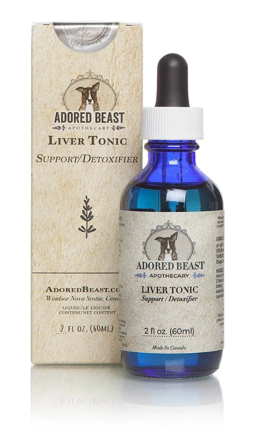 A 2 fl oz (60 ml) bottle of Adored Beast Apothecary Liver Tonic Support/Detoxifier with a blue glass dropper bottle and a beige label. The label features a logo with a dog's head, surrounded by decorative elements and the text 'Adored Beast Apothecary.' The product packaging is also shown, matching the label on the bottle, and includes the text 'AdoredBeast.com, Windsor Nova Scotia, Canada.