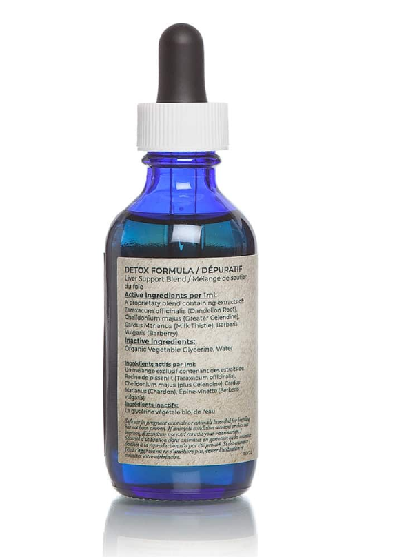 The back of a blue bottle of Adored Beast Apothecary Liver Tonic Support/Detoxifier with a white dropper cap. The label lists the active and inactive ingredients. The active ingredients per 1 ml include extracts of Taraxacum officinale (Dandelion Root), Chelidonium majus (Greater Celandine), Carduus marianus (Milk Thistle), and Berberis vulgaris (Barberry). The inactive ingredients are organic vegetable glycerine and water. The text is written in both English and French