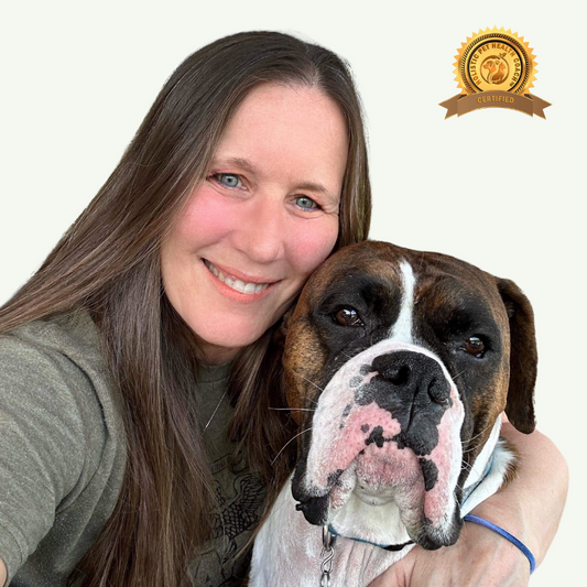 Lisa Mayer, a woman with long straight brown hair, is smiling and hugging a brown and white dog with a black nose. She is wearing a green shirt, and the dog is wearing a collar. There is a badge in the top right corner of the image that says "Certified" and includes the logo of "Holistic Pet Health Coach."