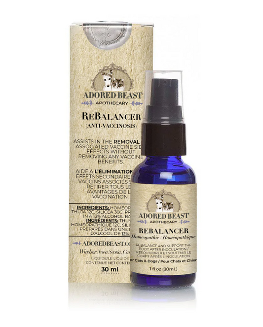 1 fl oz (30 ml) Adored Beast Apothecary ReBalancer (Anti-Vaccinosis) in a blue glass spray bottle with a beige label. The label features a dog and cat logo with decorative elements and the text 'Adored Beast Apothecary.' The packaging matches the bottle and includes the text 'Assists in the removal of associated vaccine side effects without removing any vaccine benefits,' along with the ingredient list and product details in English and French.